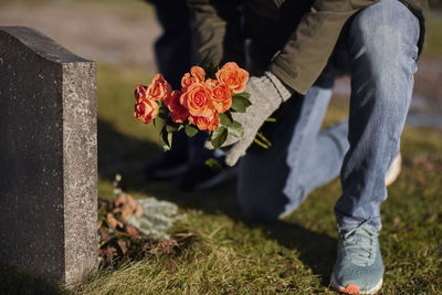 Man with flowers at cemetery