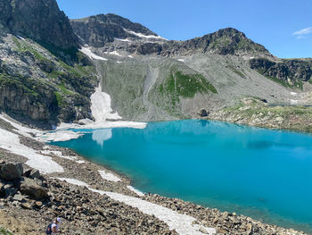 Scenic view of lake and mountains against blue sky