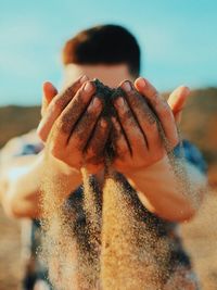 Man holding sand at beach