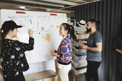 Happy businesswoman talking to colleagues in creative office