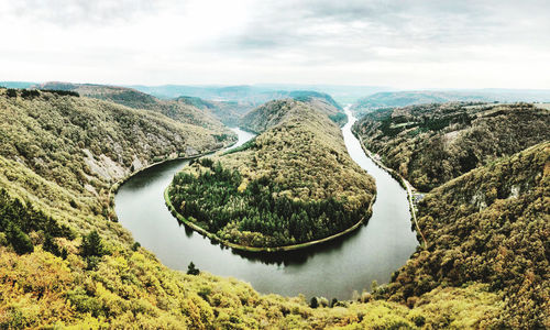 High angle view of river amidst mountains against sky