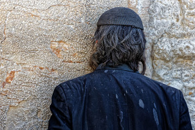 Rear view of man praying on wailing wall