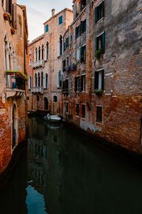 Venetian foreshortening with typical canal and boat moored under houses