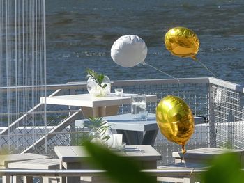 Close-up of glass with ball on table by sea