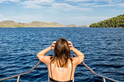 Rear view of woman in sea against sky