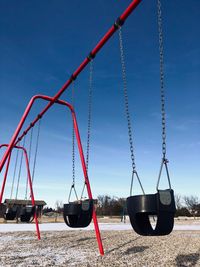 Swing at playground against clear blue sky