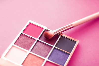 High angle view of eyeshadow and make-up brush on table