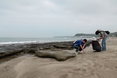 People on beach against sky