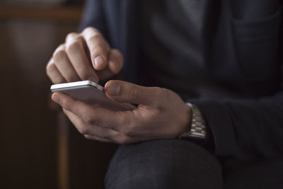 Midsection of man using mobile phone