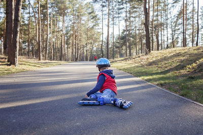 Rear view of boy riding motorcycle on road