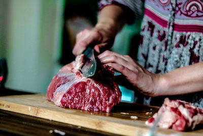 Midsection of man preparing food on cutting board