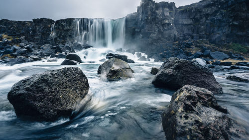 Scenic view of waterfall against sky