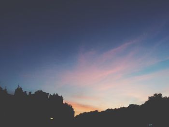 Low angle view of silhouette building against sky