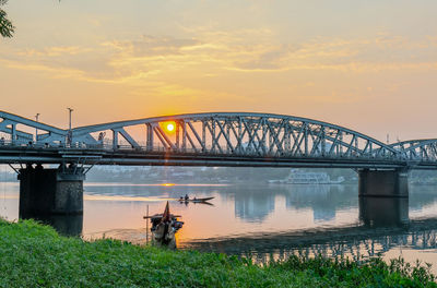 Bridge over river against sky during sunset