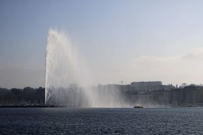 Fountain in sea against sky