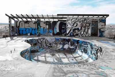 Graffiti on railing against blue sky during winter