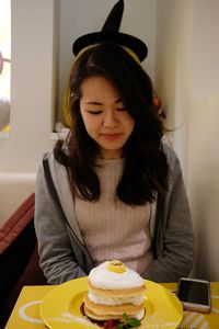 Young woman looking away while sitting at home