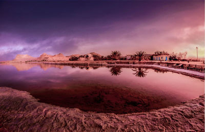 Scenic view of salt lack against sky at sunset