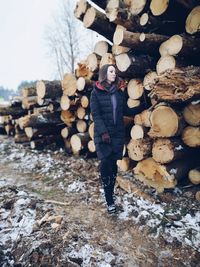 Young woman standing by log