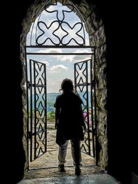 Rear view of woman standing at archway