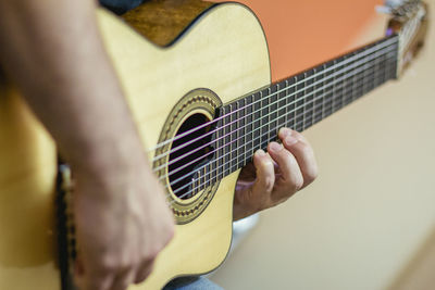 Cropped image of man playing acoustic guitar