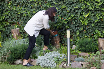 Side view of woman standing by plants