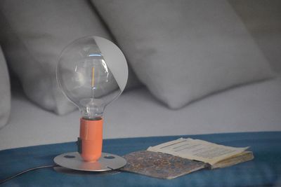 Light bulb by book on bed