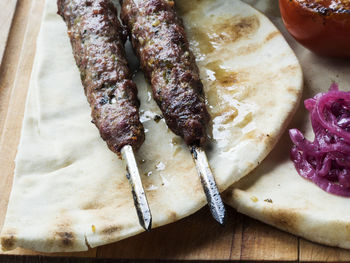 Close-up of fresh shish kebab lamb meat on skewers over cutting board