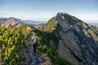 Woman hiking on footpath in alpine landscape in autumn, osterhorn mountain range, salzburg, austria