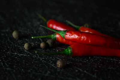 Close-up macro photography of red chili peppers on table against black background