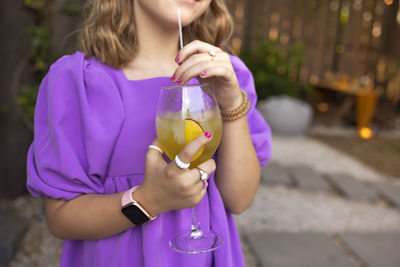 Midsection of woman holding drink