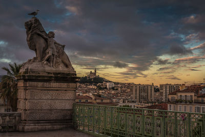 Statue of historic building against cloudy sky