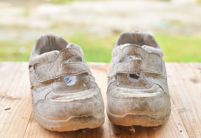 Close-up of old shoes on wooden table