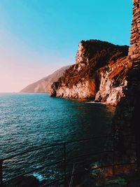 Scenic view of sea and mountains against blue sky