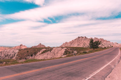 Road by mountain against sky