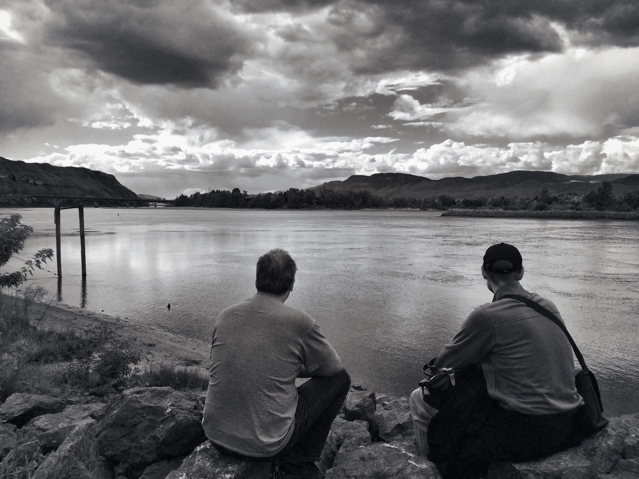 sky, rear view, cloud - sky, water, mountain, lake, lifestyles, leisure activity, men, tranquility, tranquil scene, beauty in nature, cloudy, scenics, nature, standing, sitting, mountain range