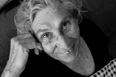 Close-up portrait of smiling woman sitting at home