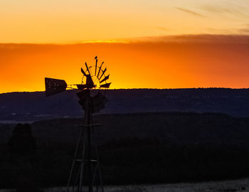 Wind turbines against sky during sunset