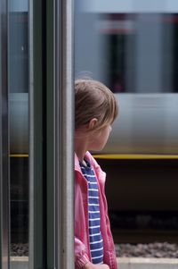 Rear view of girl looking through train window