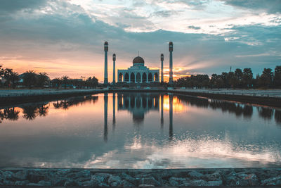 Reflection of building on lake during sunset