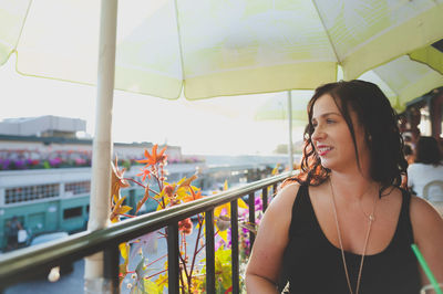 Young woman looking away while sitting at restaurant