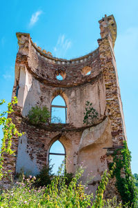 Inside view of stone wall of ancient ruined tower with windows. blue sky background.