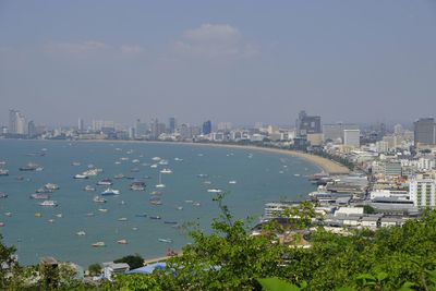 High angle view of city by sea against sky