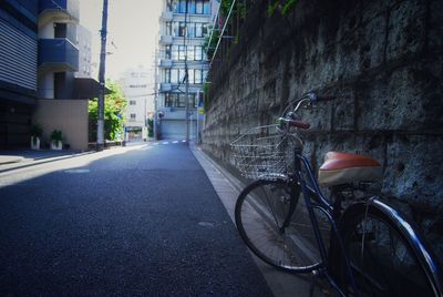 Bicycle parked on street against buildings
