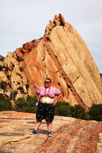 Full length of mid adult woman standing against rock formation at national park