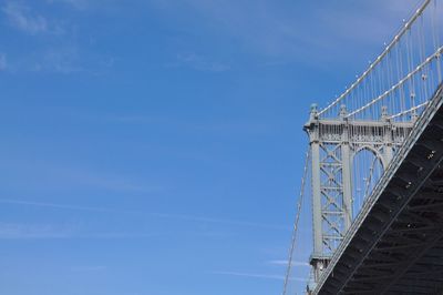 Low angle view of suspension bridge against sky