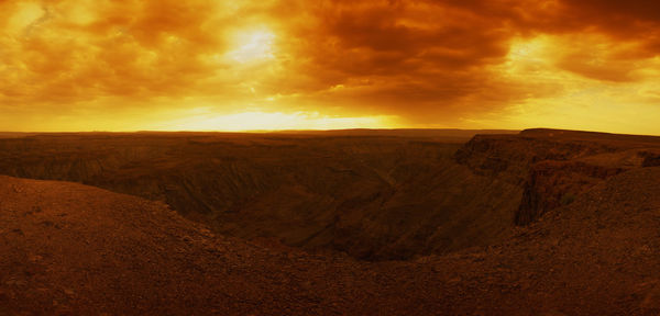 Scenic view of desert against dramatic sky
