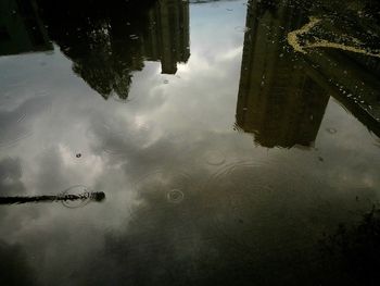 Reflection of building in puddle on lake