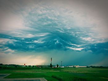 Scenic view of field against cloudy sky