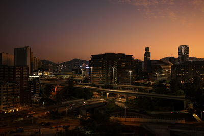 High angle view of illuminated city at sunset